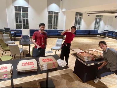 Picture of students next to pizza.